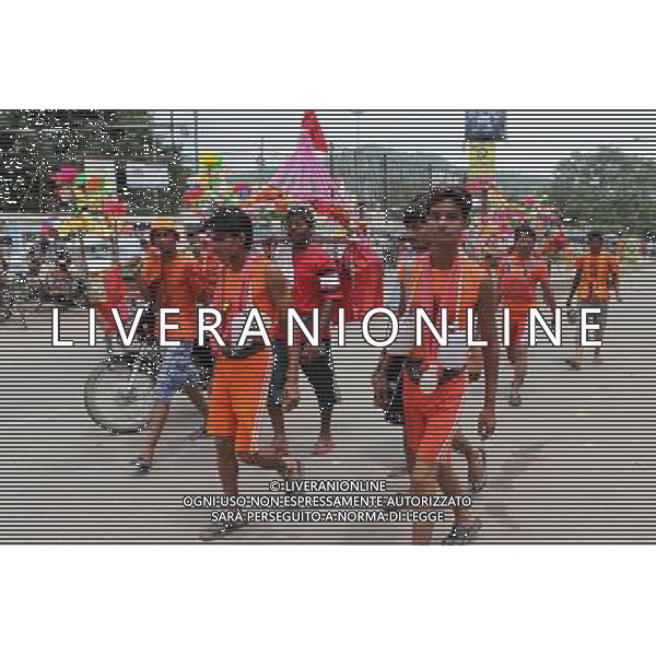 (110728) -- NEW DELHI, July 28, 2011 () -- Devotees of Hinduism carrying holy water walk on a street in Haridwar, Uttaranchal State of India, on July 27, 2011. Hindu pilgrims, also known as \'Kanwarias\', arrive barefoot from across the country and converge on the banks of the River Ganges annually to collect holy water (kanwar) from the River Ganges in Haridwar, Gangotri or Gaumukh in the northern Indian state of Uttaranchal, then pour the holy water in their hometown temples. This journey, completed on foot, is supposed to fulfil their wishes and endear them to Lord Shiva, the Hindu God of Destruction. All along the route to Haridwar, voluntary organizations put up food and medical stalls to cater to the pilgrims. (/Li Yigang) (lb)