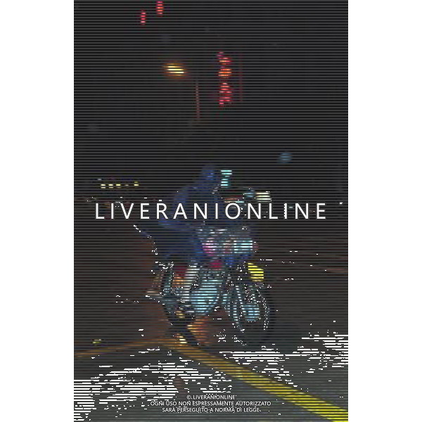 (110729) -- WENCHANG, July 29, 2011 () -- A local resident rides an autocycle in the rain caused by Nock-Ten in Wenchang City, south China\'s Hainan Province, July 29, 2011. Tropical storm Nock-Ten landed in coastal areas of Hainan Province on Friday afternoon. (/Wang Huiyu) (gsy)