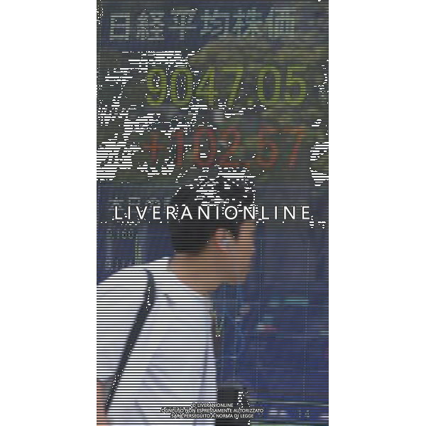 (110810) -- TOKYO, Aug. 10, 2011 () -- A man walks past an electrical board showing the Nikkei stock information in Tokyo, Aug. 10, 2011. Japanese stocks rebounded Wednesday morning, lifted by an overnight rally in the U.S. stocks after previous sell-offs. After rising more than 2 percent, the benchmark 225-issue Nikkei Stock Average finished the morning at 9,047.05, up 102.57 points, or 1.15 percent, from Tuesday. (/Kenichiro Seki) (zx)