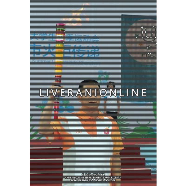 (110811) SHENZHEN, Aug. 11, 2011 () The first torchbearer Chen Runru displays the torch during the torch relay for the 26th Summer Universiade in Shenzhen, a city of south China\'s Guangdong Province, Aug. 11, 2011. (/Liu Dawei)(wll)