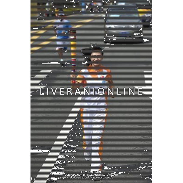 (110811) SHENZHEN, Aug. 11, 2011 () The last torchbearer Cai Mingming, a student of Shenzhen University and the delegate for the internet torch relay, relays the torch during the torch relay for the 26th Summer Universiade in Shenzhen, a city of south China\'s Guangdong Province, Aug. 11, 2011. (/Liang Xu)(wll)
