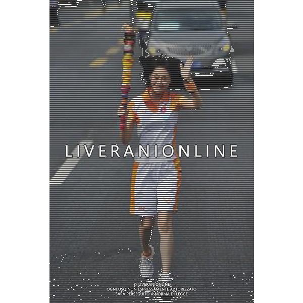 (110811) SHENZHEN, Aug. 11, 2011 () Torchbearer Lin Peng relays the torch during the torch relay for 26th Summer Universiade in Shenzhen, a city of south China\'s Guangdong Province, Aug. 11, 2011. (/Liang Xu)(wll)