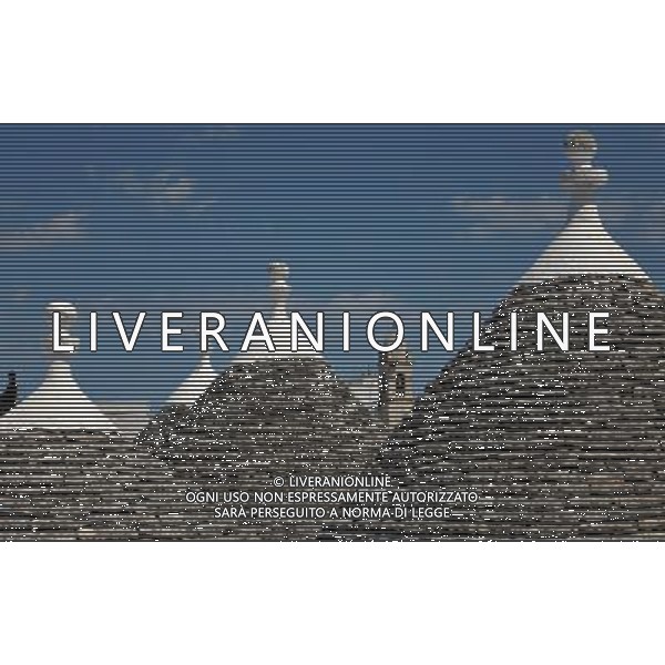 (110812) ALBEROBELLO, Aug. 12, 2011 Photo taken on Aug. 10, 2011 shows the roof of a church and Trulli in Alberobello, southern Italy. Alberobello, the city of drystone dwellings known as trulli, is an exceptional example of vernacular architecture. The trulli are made of roughly worked limestone boulders collected from neighbouring fields. Characteristically, they feature pyramidal, domed or conical roofs built up of corbelled limestone slabs. UNESCO inscribed the Trulli of Alberobello in the World Heritage List in 1996. (/Wang Qingqin)