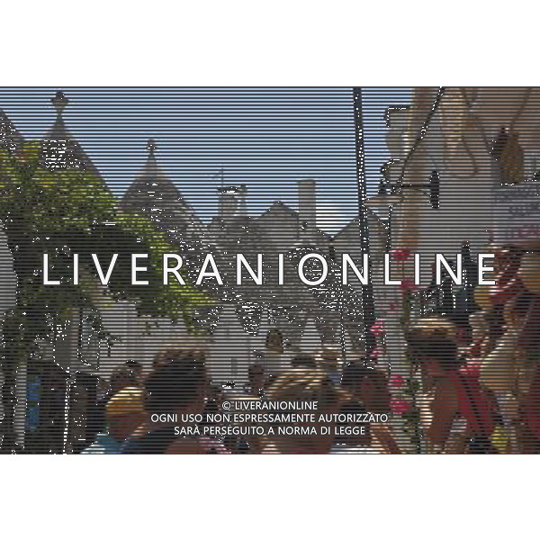 (110812) ALBEROBELLO, Aug. 12, 2011 Tourists visit the Trulli in Alberobello, southern Italy, Aug. 10, 2011. Alberobello, the city of drystone dwellings known as trulli, is an exceptional example of vernacular architecture. The trulli are made of roughly worked limestone boulders collected from neighbouring fields. Characteristically, they feature pyramidal, domed or conical roofs built up of corbelled limestone slabs. UNESCO inscribed the Trulli of Alberobello in the World Heritage List in 1996. (/Wang Qingqin)