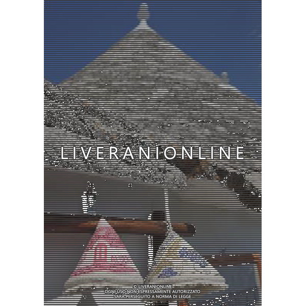 (110812) ALBEROBELLO, Aug. 12, 2011 Photo taken on Aug. 10, 2011 shows souvenir hats under the roof of a Trulli in Alberobello, southern Italy. Alberobello, the city of drystone dwellings known as trulli, is an exceptional example of vernacular architecture. The trulli are made of roughly worked limestone boulders collected from neighbouring fields. Characteristically, they feature pyramidal, domed or conical roofs built up of corbelled limestone slabs. UNESCO inscribed the Trulli of Alberobello in the World Heritage List in 1996. (/Wang Qingqin) ()