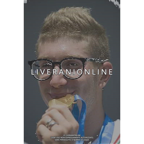 (110813) -- SHENZHEN, Aug. 13, 2011 () -- Simone Ruffini of Italy bites his gold medal during the awarding ceremony for men\'s open water 10km swimming at the 26th Summer Universiade in Shenzhen, a city of south China\'s Guangdong Province, Aug. 13, 2011. Simone Ruffini claimed the title of the event with 1 hour 58 minutes 0.747 seconds to win the first gold medal of the 26th Summer Universiade. (/Lui Siu Wai)(kh)