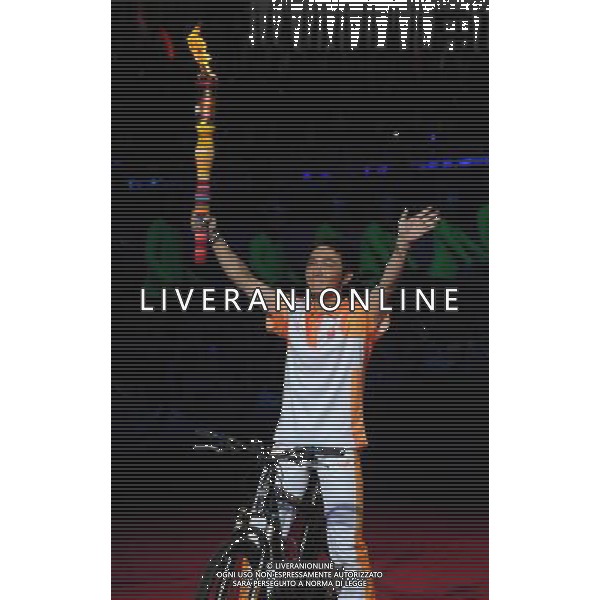 (110812) -- SHENZHEN, Aug. 12, 2011 () -- Torchbearer Shenzhen student Zhou Ziqian gestures on his bicycle during the opening ceremony of the 26th Summer Universiade in Shenzhen, a city of south China\'s Guangdong Province, on Aug. 12, 2011. (/Yang Shiyao)(kh)