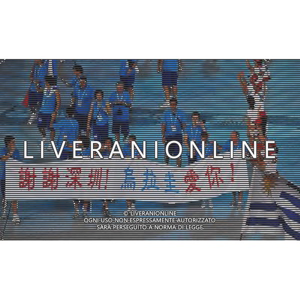 (110812) -- SHENZHEN, Aug. 12, 2011 () -- Members of Uruguay\'s delegation hold a banner of \'Thank you, Shenzhen! Uruguay loves you!\' in Chinese characters as they enter the site during the opening ceremony of the 26th Summer Universiade in Shenzhen, a city of south China\'s Guangdong Province, on Aug. 12, 2011. (/Chen Yehua)(kh)