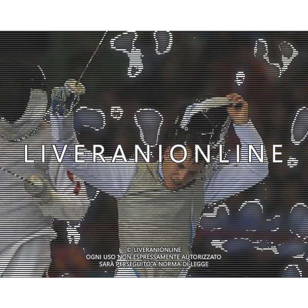 SHENZHEN, Aug. 15, 2011 Martino Minuto (R) of Italy takes off the face guard after winning men\'s foil individual final against Lei Sheng of China at the 26th Summer Universiade in Shenzhen, a city of south China\'s Guangdong Province, Aug. 15, 2011. Martino Minuto won 15 13 to claim the title of the event. (/Guo Yong)(kh)