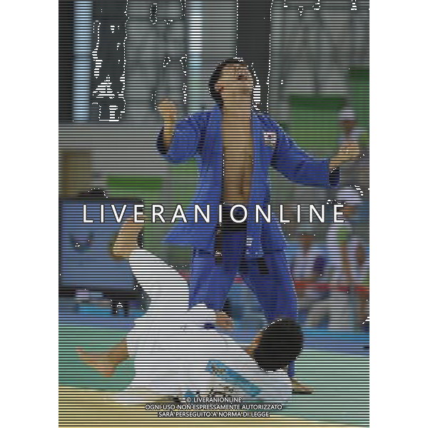SHENZHEN, Aug. 15, 2011 Hwang Bo Bae of South Korea (blue) celebrates winning over Yuito Yoshida of Japan during their men\'s Judo 66KG final match at the 26th Summer Universiade in Shenzhen, a city of south China\'s Guangdong Province, Aug. 15, 2011. Hwang Bo Bae defeated Yuito Yoshida and claimed the gold medal of the event. (/Liu Dawei)