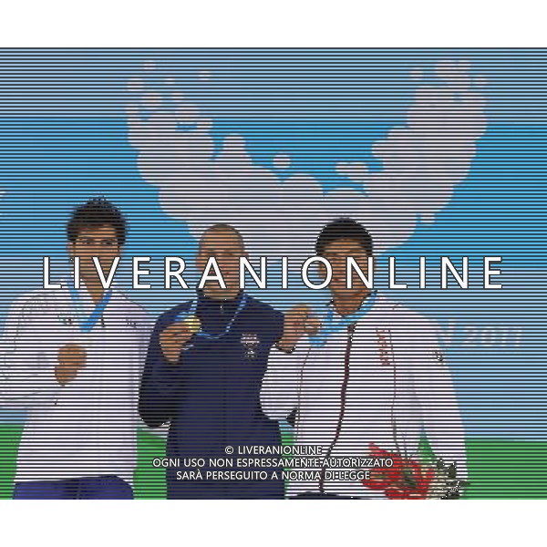 SHENZHEN, Aug. 15, 2011 Gold medalist Timothy Phillips (C) of the United States, silver medalist Paolo Facchinelli (L) of Italy and bronze medalist Masayuki Kishida of Japan pose on the podium during the awarding ceremony of men\'s 50m butterfly final of swimming at the 26th Summer Universiade in Shenzhen, a city of south China\'s Guangdong Province, Aug. 15, 2011. (/Chen Jianli)