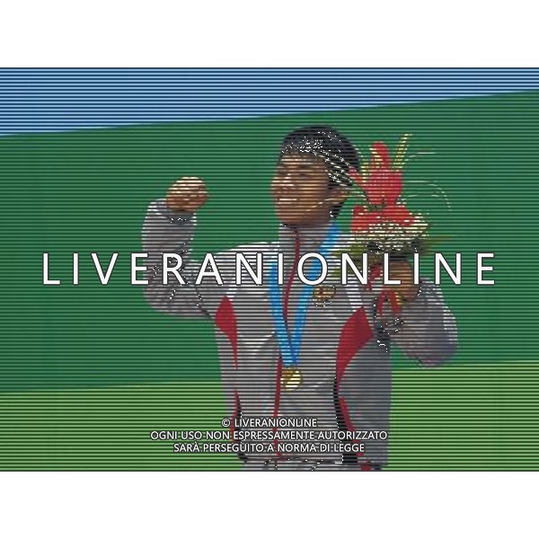 SHENZHEN, Aug. 15, 2011 Deni of Indonesia reacts during the awarding ceremony for the men\'s 69kg of weightlifting at the 26th Summer Universiade in Shenzhen, a city of south China\'s Guangdong Province, Aug. 15, 2011. Deni won the gold medal with a total of 321kg. (/Wang Song) (kh)