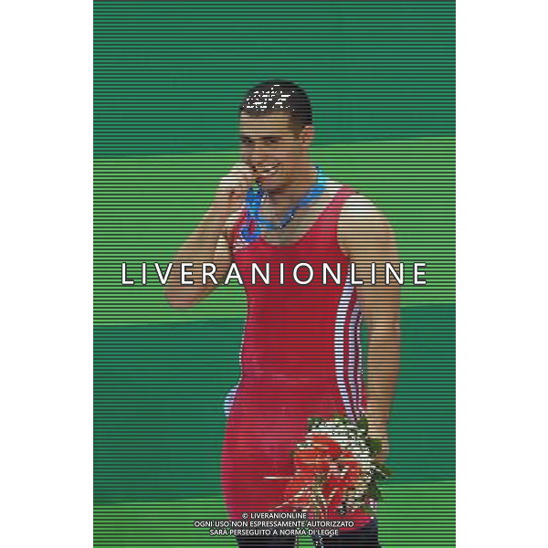 (110815) -- SHENZHEN, Aug. 15, 2011 () -- Aghasyan Aghasi of Armenia reacts during the awarding ceremony for men\'s 77kg weightlifting at the 26th Summer Universiade in Shenzhen, a city of south China\'s Guangdong Province, Aug. 15, 2011. Aghasyan Aghasi won the gold with a total of 337kg. (/Wang Song) (kh)