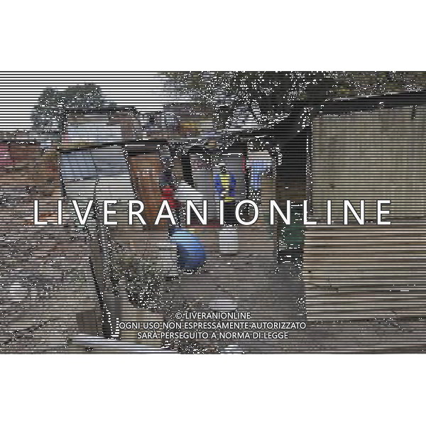 JOHANNESBURG, Aug. 16, 2011 Erle Aris Merz and his son stand in front of their home at a slum in Samampelo,Johannesburg, South Africa, Aug. 14, 2011. Over 15,000 people live in this slum, most of whom live on hard labour or small business. (/Li Qihua) (msq)