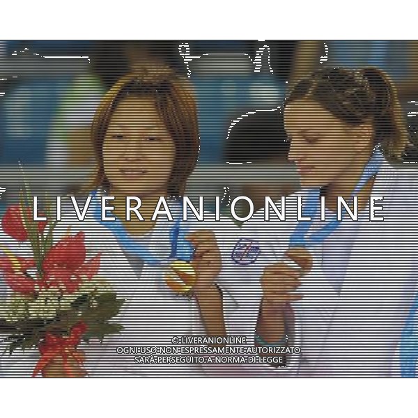 SHENZHEN, Aug. 16, 2011 Kaori Kondo of Japan (L) displays her gold medal as Violeta Dumitru of Romania looks on at the awarding ceremony of women\'s Judo 48KG competition at the 26th Summer Universiade in Shenzhen, a city of south China\'s Guangdong Province, Aug. 16, 2011. (/Liu Dawei)