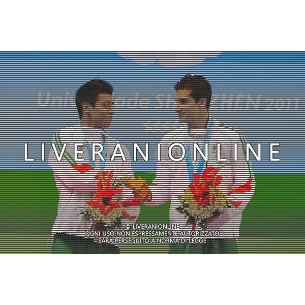 SHENZHEN, Aug. 16, 2011 Mexico\'s Rommel Pacheco shakes hands with his teammate Jonathan Ruvalcab during the awarding ceremony for the men\'s synchronised 3m springboard of diving event at the 26th Summer Universiade, in Shenzhen, a city of south China\'s Guangdong Province, Aug. 16, 2011. Pacheco and Ruvalcab won the silver medal with 385.32 points. (/Lu Hanxin)(bxf)