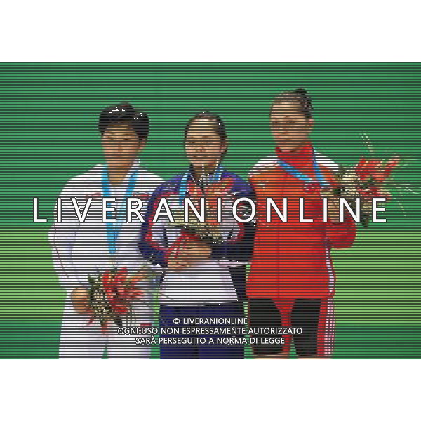 SHENZHEN, Aug. 16, 2011 Gold medalist Ho Hsiaochun of Chinese Taipei (C), silver medalist Kim Yun Jong of the Democratic People\'s Republic of Korea (L) and bronze medalist Ince Seda of Turkey pose for group photos at the awarding ceremony of women\'s 63kg weightlifting competition at the 26th Summer Universiade in Shenzhen, a city of south China\'s Guangdong Province, Aug. 16, 2011. (/Wang Song)