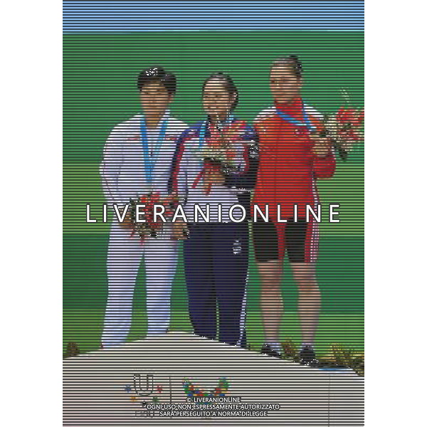 SHENZHEN, Aug. 16, 2011 Gold medalist Ho Hsiaochun of Chinese Taipei (C), silver medalist Kim Yun Jong of the Democratic People\'s Republic of Korea (L) and bronze medalist Ince Seda of Turkey pose for group photos at the awarding ceremony of women\'s 63kg weightlifting competition at the 26th Summer Universiade in Shenzhen, a city of south China\'s Guangdong Province, Aug. 16, 2011. (/Wang Song)