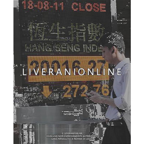 (110818) HONG KONG, Aug. 18, 2011 A pedestrian walks past an electronic panel showing the Hang Seng Index in Hong Kong, south China, Aug. 18, 2011. Hong Kong\'s Hang Seng Index plunged by 272.76 points, or 1.34 percent, to end at 20016.27 points on Thursday. (/Wong Pun Keung)