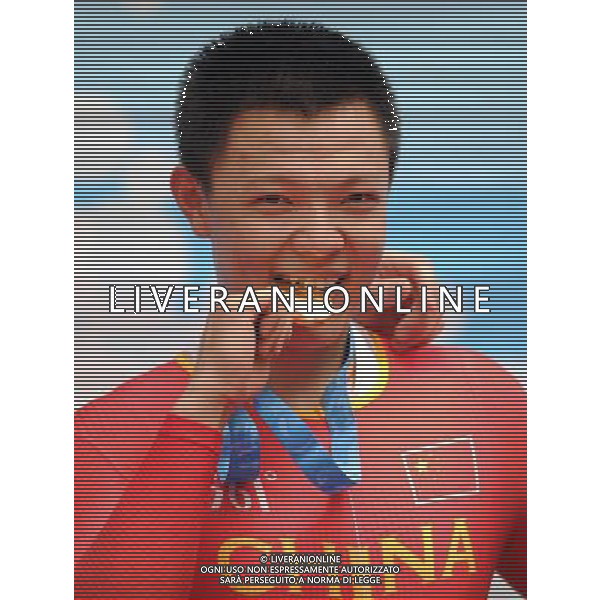 (110819) -- SHENZHEN, Aug. 19, 2011 () -- Gold medalist Zhang Miao of China bites his medal during the awarding ceremony of men\'s keirin of cycling track at the 26th Summer Universiade in Shenzhen, a city of south China\'s Guangdong Province, on Aug. 19, 2011. (/Li Ga)(wx)
