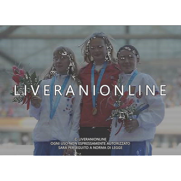 (110819) -- SHENZHEN, Aug. 19, 2011 () -- Gold medalist Julia Takacs Nyerges (C) of Spain, silver medalist Tatiana Shemyakina (L) of Russia and bronze medalist Nina Okhotnikova of Russia pose for photos during the awarding ceremony of women\'s 20km walk of athletics event at the 26th Summer Universiade in Shenzhen, a city of south China\'s Guangdong Province, on Aug. 19, 2011. Takacs Nyerges claimed the title of the event with 1 hour 33 minutes 51 seconds. (/Lui Siu Wai) (bxf)