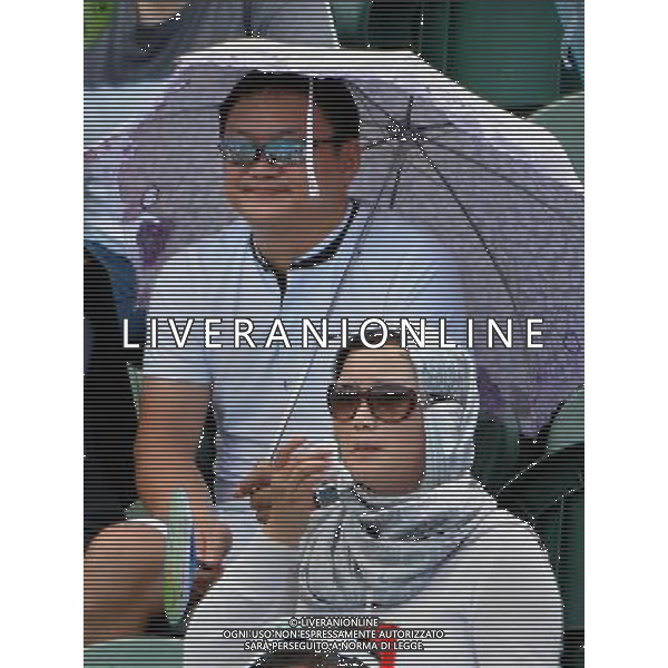 (110822) -- SHENZHEN, Aug. 22, 2011 () -- Spectators use shawl and umbrella to avoid sunburn during tennis matches of the 26th Summer Universiade in Longgang Tennis Center in Shenzhen, a city of south China\'s Guangdong Province, on Aug. 21, 2011. (/Wang Song)(wx)