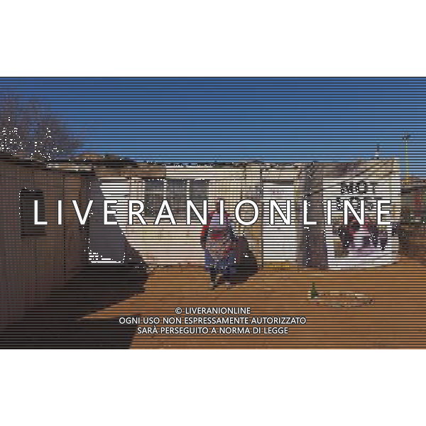 (110831) -- JOHANNESBURG, Aug. 31, 2011 () -- Thandi Madlanke stands in front of her sheet iron house at the Ramseg Informal settlement at the Motswaledi Informal settlement in Soweto, Johannesburg, South Africa, Aug. 24, 2011. One of the most common landscapes in Johannesburg and even the whole South Africa is slum, some of which stretche for miles and are populated with hundreds and thousands of people. For most of the inhabitants, their houses are made from scrap materials such as wooden stakes or corrugated metal. Although living in a shanty town, poverty cannot stop their pursuit for beauty, nor ruin their impulse in life. Therefore, they find a way to express their love for life, to painting on the iron sheet house. (/Fei Maohua) (msq)