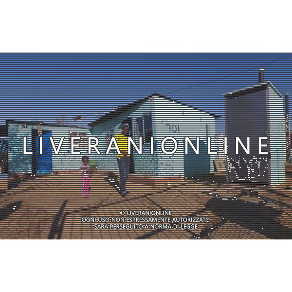 (110831) -- JOHANNESBURG, Aug. 31, 2011 () -- Nkosikhona Zenani stands in front of his sheet iron house at the Motswaledi Informal settlement in Soweto, Johannesburg, South Africa, Aug. 24, 2011. One of the most common landscapes in Johannesburg and even the whole South Africa is slum, some of which stretche for miles and are populated with hundreds and thousands of people. For most of the inhabitants, their houses are made from scrap materials such as wooden stakes or corrugated metal. Although living in a shanty town, poverty cannot stop their pursuit for beauty, nor ruin their impulse in life. Therefore, they find a way to express their love for life, to painting on the iron sheet house.(/Fei Maohua) (msq)