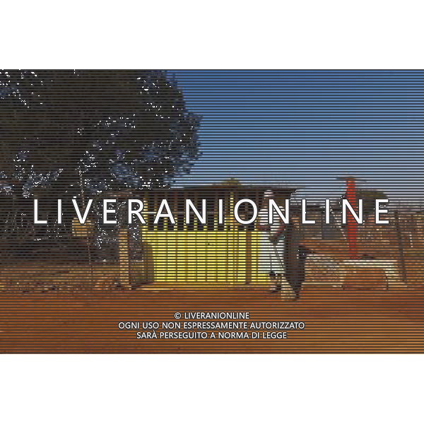 (110831) -- JOHANNESBURG, Aug. 31, 2011 () -- Nomsa Magalanyane stands in front of her candy shop at the Thembelihle Informal settlement, Johannesburg, South Africa, Aug. 25, 2011. One of the most common landscapes in Johannesburg and even the whole South Africa is slum, some of which stretche for miles and are populated with hundreds and thousands of people. For most of the inhabitants, their houses are made from scrap materials such as wooden stakes or corrugated metal. Although living in a shanty town, poverty cannot stop their pursuit for beauty, nor ruin their impulse in life. Therefore, they find a way to express their love for life, to painting on the iron sheet house.(/Fei Maohua) (msq)