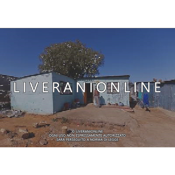 (110831) -- JOHANNESBURG, Aug. 31, 2011 () -- Alex Tyabule stands in front of his sheet iron house at the Motswaledi Informal settlement in Soweto, Johannesburg, South Africa, Aug. 24, 2011. One of the most common landscapes in Johannesburg and even the whole South Africa is slum, some of which stretche for miles and are populated with hundreds and thousands of people. For most of the inhabitants, their houses are made from scrap materials such as wooden stakes or corrugated metal. Although living in a shanty town, poverty cannot stop their pursuit for beauty, nor ruin their impulse in life. Therefore, they find a way to express their love for life, to painting on the iron sheet house.(/Fei Maohua) (msq)