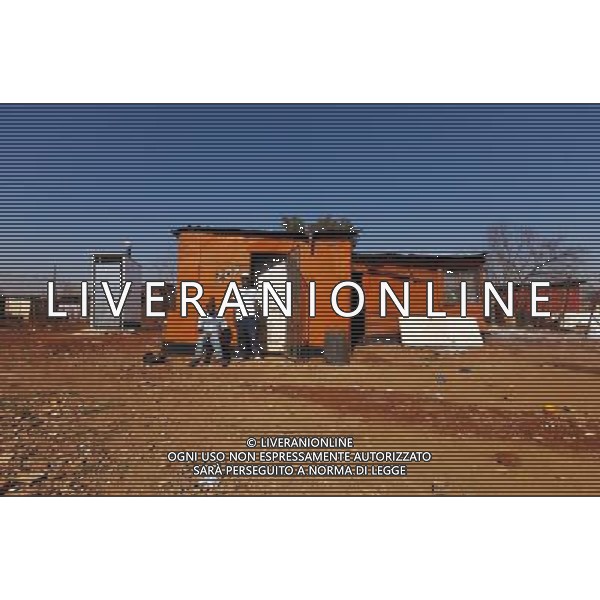(110831) -- JOHANNESBURG, Aug. 31, 2011 () -- Allen Mutswene (R) stands in front of his sheet iron house with his friend Mzwakhe NGcobo at the Thembelihle Informal settlement, Johannesburg, South Africa, Aug. 25, 2011. One of the most common landscapes in Johannesburg and even the whole South Africa is slum, some of which stretche for miles and are populated with hundreds and thousands of people. For most of the inhabitants, their houses are made from scrap materials such as wooden stakes or corrugated metal. Although living in a shanty town, poverty cannot stop their pursuit for beauty, nor ruin their impulse in life. Therefore, they find a way to express their love for life, to painting on the iron sheet house.(/Fei Maohua) (msq)