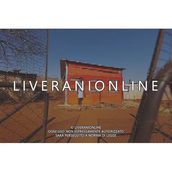 (110831) -- JOHANNESBURG, Aug. 31, 2011 () -- Jmashudu Mmnkheru stands in front of his sheet iron house at the Thembelihle Informal settlement, Johannesburg, South Africa, Aug. 25, 2011. One of the most common landscapes in Johannesburg and even the whole South Africa is slum, some of which stretche for miles and are populated with hundreds and thousands of people. For most of the inhabitants, their houses are made from scrap materials such as wooden stakes or corrugated metal. Although living in a shanty town, poverty cannot stop their pursuit for beauty, nor ruin their impulse in life. Therefore, they find a way to express their love for life, to painting on the iron sheet house.(/Fei Maohua) (msq)