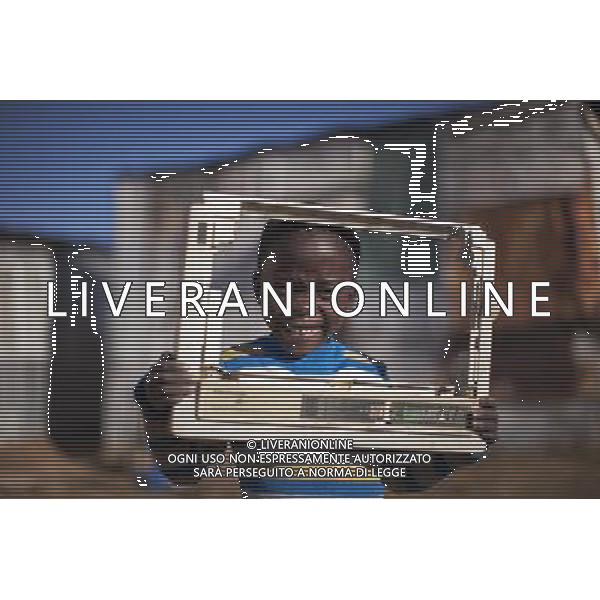 JOHANNESBURG , Sept. 01, 2011 5 year old Phelo poses with a cover plate of an electric equipment he found in trash, in Motswaledi Informal settlement of Soweto, Johannesburg, South Africa, Aug. 24, 2011. Children in the shanty towns don\'t have fancy toys like transformers, barbies or remote control airplanes, but they have a lot of fun playing with a piece of wire, a ball, a discarded circuit board or even a piece of paper. These so called toys bring happiness to the children, though heart breaking it may seem to others. (/Fei Maohua) (xhn)