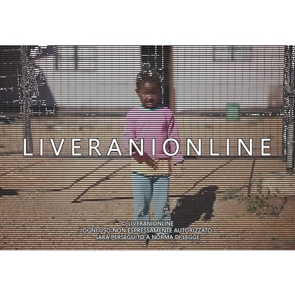 JOHANNESBURG , Sept. 01, 2011 5 year old Phelokazi Zimkita holds two bottle caps as toys in hands in Motswaledi Informal settlement of Soweto, Johannesburg, South Africa, Aug. 24, 2011. Children in the shanty towns don\'t have fancy toys like transformers, barbies or remote control airplanes, but they have a lot of fun playing with a piece of wire, a ball, a discarded circuit board or even a piece of paper. These so called toys bring happiness to the children, though heart breaking it may seem to others. (/Fei Maohua) (xhn)