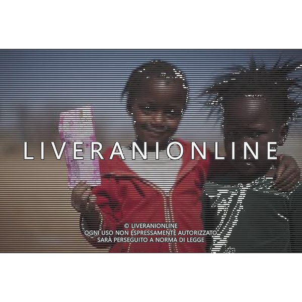 JOHANNESBURG , Sept. 01, 2011 4 year old Pulani Lithabeng and Katlego Mthombeni shows off a beautifully printed package paper in Sweet Water Informal Settlement in Johannesburg, South Africa, Aug. 25, 2011. Children in the shanty towns don\'t have fancy toys like transformers, barbies or remote control airplanes, but they have a lot of fun playing with a piece of wire, a ball, a discarded circuit board or even a piece of paper. These so called toys bring happiness to the children, though heart breaking it may seem to others. (/Fei Maohua) (xhn)