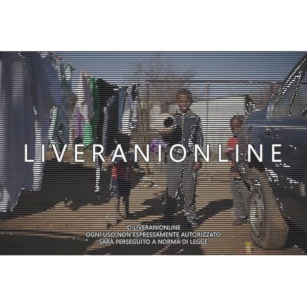 JOHANNESBURG , Sept. 01, 2011 10 year old Sesethu Ngcinasee holds a discarded soccer as toy in Motswaledi Informal settlement of Soweto, Johannesburg, South Africa, Aug. 24, 2011. Children in the shanty towns don\'t have fancy toys like transformers, barbies or remote control airplanes, but they have a lot of fun playing with a piece of wire, a ball, a discarded circuit board or even a piece of paper. These so called toys bring happiness to the children, though heart breaking it may seem to others. (/Fei Maohua) (xhn)