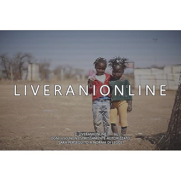 JOHANNESBURG , Sept. 01, 2011 4 year old Pulani Lithabeng and Katlego Mthombeni shows off a beautifully printed package paper in Sweet Water Informal Settlement in Johannesburg, South Africa, Aug. 25, 2011. Children in the shanty towns don\'t have fancy toys like transformers, barbies or remote control airplanes, but they have a lot of fun playing with a piece of wire, a ball, a discarded circuit board or even a piece of paper. These so called toys bring happiness to the children, though heart breaking it may seem to others. (/Fei Maohua) (xhn)