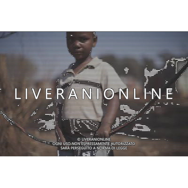 JOHANNESBURG , Sept. 01, 2011 4 year old Nhlanhla poses behind his swing made from the rubber skin of a piece of cable, in Motswaledi Informal settlement of Soweto, Johannesburg, South Africa, Aug. 25, 2011. Children in the shanty towns don\'t have fancy toys like transformers, barbies or remote control airplanes, but they have a lot of fun playing with a piece of wire, a ball, a discarded circuit board or even a piece of paper. These so called toys bring happiness to the children, though heart breaking it may seem to others. (/Fei Maohua) (xhn)