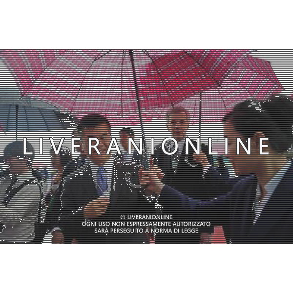 (110914) -- DALIAN, Sept. 14, 2011 () -- A staff worker holds an umbrella for a participant attending the World Economic Forum Annual Meeting of the New Champions, also known as the Summer Davos Forum, in Dalian, a coastal city in northeast China\'s Liaoning Province, Sept. 14, 2011. The forum, scheduled on Sept. 14-16, has attracted some 1,700 participants from 90 countries and regions to discuss topics about economic structure and growth quality. (/Jiang Bing) (mcg)