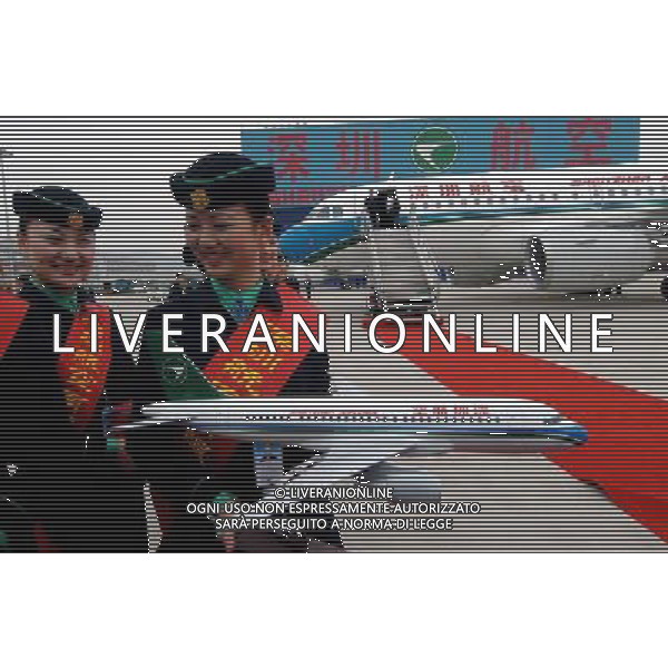 (110913) SHENZHEN, Sept. 13, 2011 () File photo taken on Feb. 17, 2006 shows two stewardesses of Shenzhen Airlines carry an A319 model during a ceremony to receive two Airbus planes from German in Shenzhen City, south China\'s Guangdong Province. Shenzhen Airline became Airbus\' client in 2006. An Airbus A319 aircraft, painted with yellow, blue and green stripes on white fuselage, a symbol of rainbows and plateau purity of southwest China\'s Tibet Autonomous Region, found its home in Tibet as the first airplane of Tibet Airlines in July. Labeled with \'Tibet Airlines\' in Chinese Han, English and Tibetan languages, the A319 sheds a Tibetan flavor Tibet style interior, stewardesses of Tibetan ethnic group in traditional costumes, on board service in three languages, etc. More importantly, the airplane has a stronger \'heart\' specially modified engines to Tibet Airlines specification for flying above the roof of the world. The systems on the A319 was also modified to supply oxygen for 55 minutes, compared with the usual time of 22 minutes for aircraft that do not serve the plateau region. The 26 year history of Airbus in China is a path from the bottom to the top, for its present arch rival Boeing almost held the whole market when Airbus first landed in China in 1985. But now it has already griped 45 percent market share. Airbus\' fast growth in China may lie on its strategy of localization, or developing suppliers and building manufacturing centers in the labor cost country. All Airbus commercial aircraft now have components produced in China with six Chinese companies are involved in manufacturing parts for Airbus jet liners, adding a strong \'Chinese flavor\' to the big airplane family, even the largest passenger jet A380. In 2009, the Tianjin A320 assembly line, the first for Airbus outside Europe, came on stream. The joint venture takes charge of assembling four types of Airbus A320 series planes for the world. In the yea