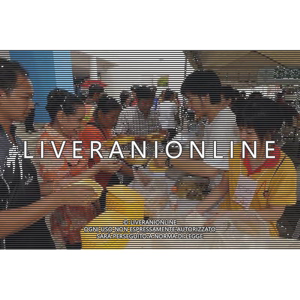 (111013) BANGKOK, Oct. 13, 2011 () Volunteers distribute food at a temporary shelter for people displaced by floods, at Thammasat University Convention Center in Thailand\'s capital Bangkok on Oct. 13, 2011. A total of 283 people were confirmed dead and two others were missing in the floods that have inundated the upper part of the country for almost three months, the Disaster Prevention and Mitigation Department reported on Thursday. (/Song Zhenping) (nxl)