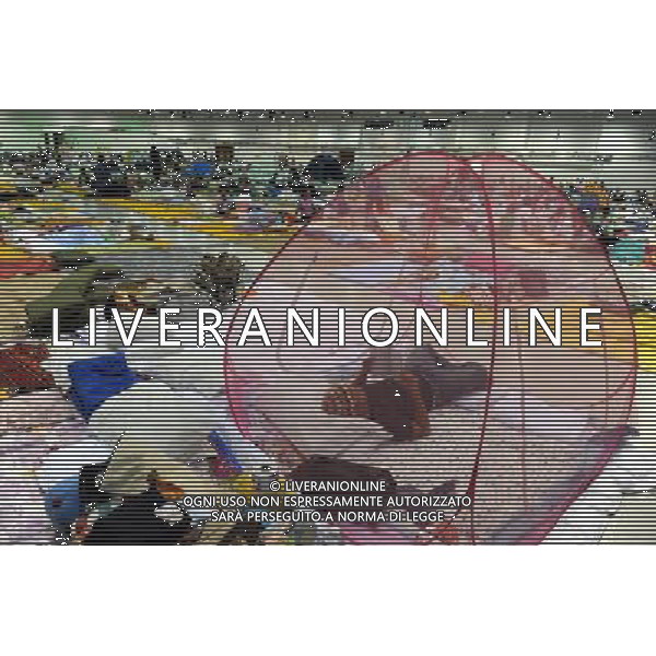 (111013) BANGKOK, Oct. 13, 2011 () A man reads a book at a temporary shelter for people displaced by floods, at Thammasat University Convention Center in Thailand\'s capital Bangkok on Oct. 13, 2011. A total of 283 people were confirmed dead and two others were missing in the floods that have inundated the upper part of the country for almost three months, the Disaster Prevention and Mitigation Department reported on Thursday. (/Song Zhenping) (nxl)