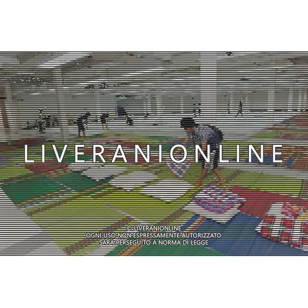 (111013) BANGKOK, Oct. 13, 2011 () Volunteers prepare mattresses for newcomers at a temporary shelter for people displaced by floods, at Thammasat University Convention Center in Thailand\'s capital Bangkok on Oct. 13, 2011. A total of 283 people were confirmed dead and two others were missing in the floods that have inundated the upper part of the country for almost three months, the Disaster Prevention and Mitigation Department reported on Thursday. (/Song Zhenping) (nxl)