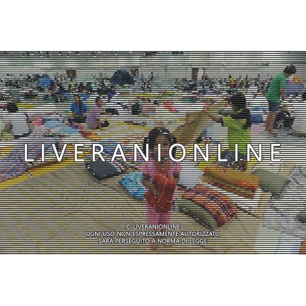 (111013) BANGKOK, Oct. 13, 2011 () A girl helps carry a blanket at a temporary shelter for people displaced by floods, at Thammasat University Convention Center in Thailand\'s capital Bangkok on Oct. 13, 2011. A total of 283 people were confirmed dead and two others were missing in the floods that have inundated the upper part of the country for almost three months, the Disaster Prevention and Mitigation Department reported on Thursday. (/Song Zhenping) (nxl)