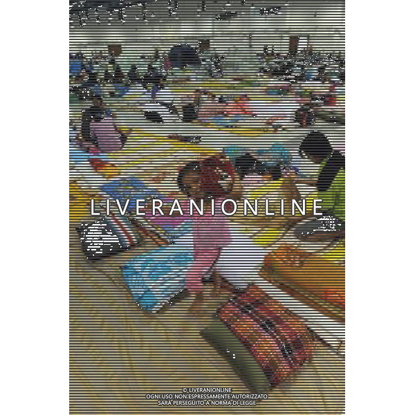 (111013) BANGKOK, Oct. 13, 2011 () A girl helps carry a blanket at a temporary shelter for people displaced by floods, at Thammasat University Convention Center in Thailand\'s capital Bangkok on Oct. 13, 2011. A total of 283 people were confirmed dead and two others were missing in the floods that have inundated the upper part of the country for almost three months, the Disaster Prevention and Mitigation Department reported on Thursday. (/Song Zhenping) (nxl)