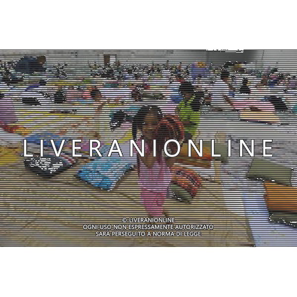 (111013) BANGKOK, Oct. 13, 2011 () A girl helps carry a blanket at a temporary shelter for people displaced by floods, at Thammasat University Convention Center in Thailand\'s capital Bangkok on Oct. 13, 2011. A total of 283 people were confirmed dead and two others were missing in the floods that have inundated the upper part of the country for almost three months, the Disaster Prevention and Mitigation Department reported on Thursday. (/Song Zhenping) (nxl)