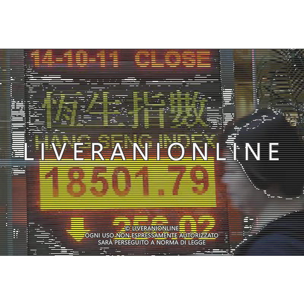 (111014) HONG KONG, Oct. 14 () A pedestrian walks past an electronic panel showing the Hang Seng Index in Hong Kong, south China, Oct. 14, 2011. Hong Kong stocks fell 256.02 points, or 1.36 percent, to close at 18,501.79 on Friday. (/Wong Pun Keung) (ljh) ©photoshot/Agenzia Aldo Liverani Sas - ITALY ONLY - Tabellone elettronico che mostra l\'indice della borsa di Hong Kong, Cina del sud, 14 ottobre 2011.