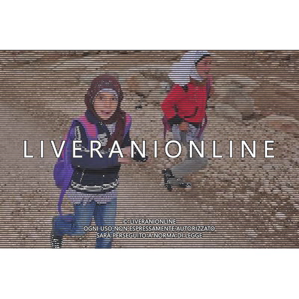 (111116) -- JERUSALEM, Nov. 16, 2011 () -- Two girl students go home after class in Imneizil village, near the West Bank city of Hebron, on Nov. 16, 2011. Imneizil village is off the electricity, water and sewage networks due to Israeli military restrictions on Palestinian development in Area C, which were marked out during negotiations between Israel and the Palestinian Authority in 1995. Israel has full control over security, planning and zoning in the area, which covers around 62 percent of the West Bank.(/Yin Dongxun) (zjl) ©photoshot/Agenzia Aldo Liverani Sas - ITALY ONLY - Donne e bambini del villaggio Imneizil, vicino alla citta\' cisgiordana di Hebron, il 16 novembre, 2011. Il villaggio e\' privo della rete elettrica, acqua e fognature a causa delle restrizioni militari israeliane sullo sviluppo palestinese nell\'area C, che sono stati tracciati durante i negoziati tra Israele e l\'Autorita\' palestinese nel 1995. Israele ha il pieno controllo della sicurezza, la pianificazione e la zonizzazione della zona, che copre circa il 62 per cento della Cisgiordania.