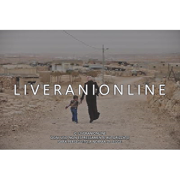 (111116) -- JERUSALEM, Nov. 16, 2011 () -- A woman walks with her son in Imneizil village, near the West Bank city of Hebron, on Nov. 16, 2011. Imneizil village is off the electricity, water and sewage networks due to Israeli military restrictions on Palestinian development in Area C, which were marked out during negotiations between Israel and the Palestinian Authority in 1995. Israel has full control over security, planning and zoning in the area, which covers around 62 percent of the West Bank.(/Yin Dongxun) (zjl) ©photoshot/Agenzia Aldo Liverani Sas - ITALY ONLY - Donne e bambini del villaggio Imneizil, vicino alla citta\' cisgiordana di Hebron, il 16 novembre, 2011. Il villaggio e\' privo della rete elettrica, acqua e fognature a causa delle restrizioni militari israeliane sullo sviluppo palestinese nell\'area C, che sono stati tracciati durante i negoziati tra Israele e l\'Autorita\' palestinese nel 1995. Israele ha il pieno controllo della sicurezza, la pianificazione e la zonizzazione della zona, che copre circa il 62 per cento della Cisgiordania.