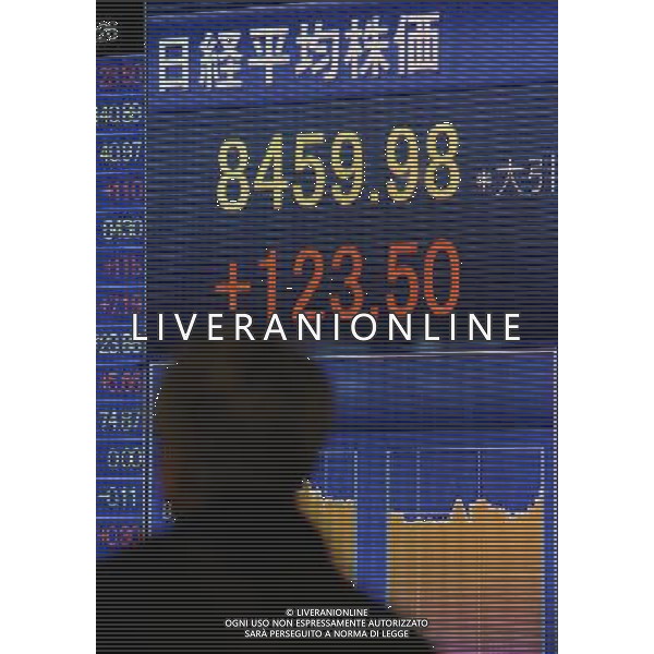 (111221) -- TOKYO, Dec. 21, 2011 () -- A pedestrian walks past an electronic information screen of share price in Tokyo, Japan, on Dec. 21, 2011. Tokyo stocks closed sharply higher Wednesday with the key Nikkei index surging 1.48 percent on eased worries about the Eurozone debt crisis and upbeat U.S. economic data. © Photoshot / ALDO LIVERANI SAS - ITALY ONLY
